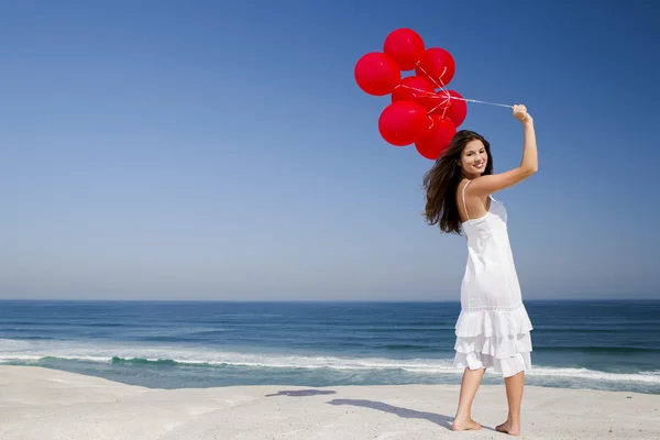 Menina bonita segurando balões vermelhos — Fotografia de Stock