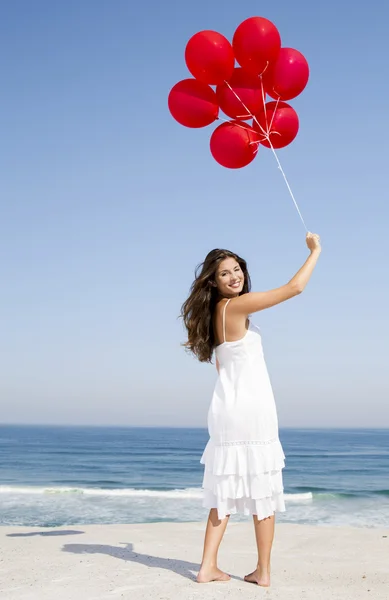 Hermosa chica sosteniendo globos rojos — Foto de Stock