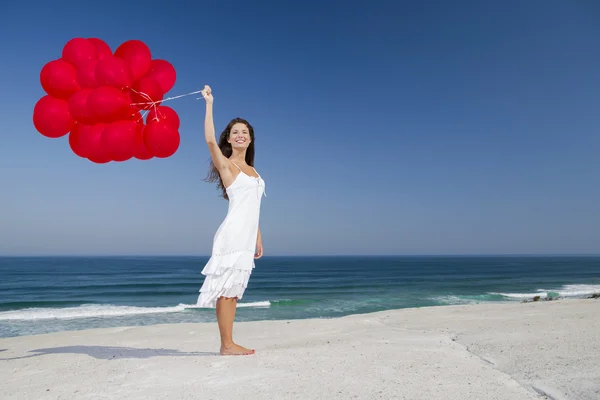 Menina bonita segurando balões vermelhos — Fotografia de Stock