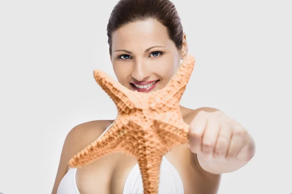Beautiful woman holding a starfish — Stock Photo, Image