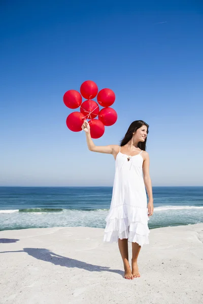 Beautiful girl holding red ballons — Stock Photo, Image