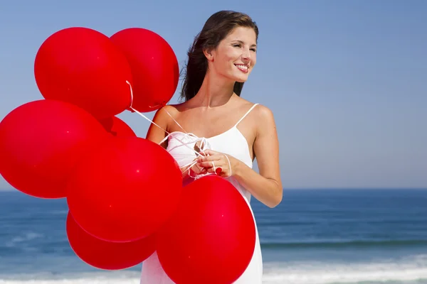 Hermosa chica sosteniendo globos rojos — Foto de Stock