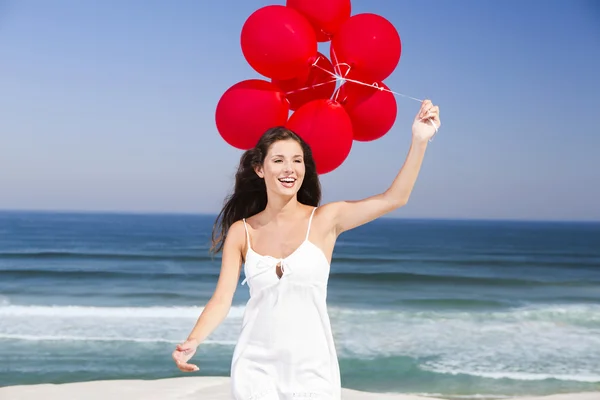 Hermosa chica sosteniendo globos rojos — Foto de Stock