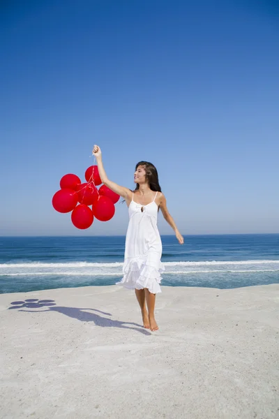 Schönes Mädchen läuft mit roten Luftballons — Stockfoto