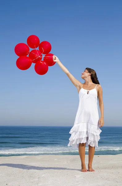 Hermosa chica sosteniendo globos rojos —  Fotos de Stock