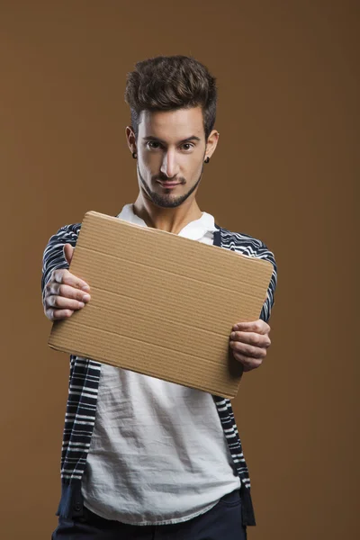 Jovem segurando uma placa de cartão — Fotografia de Stock