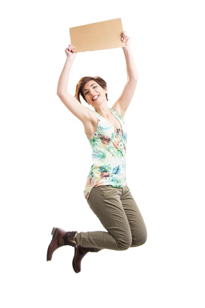 Beautiful woman jumping and holding a cardboard — Stock Photo, Image