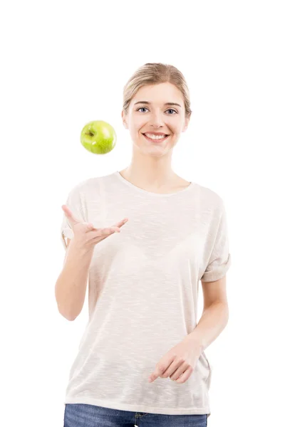 Kaunis nainen heittää vihreä omena — kuvapankkivalokuva