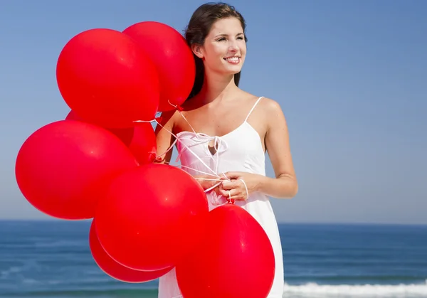 Hermosa chica sosteniendo globos rojos —  Fotos de Stock