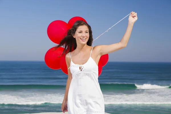 Hermosa chica sosteniendo globos rojos — Foto de Stock