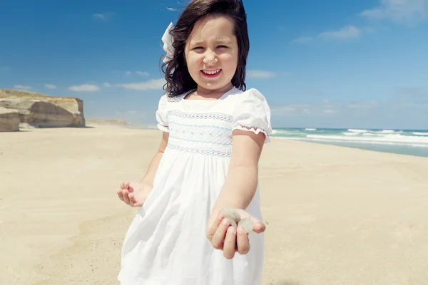 Mädchen am Strand mit Steinen — Stockfoto