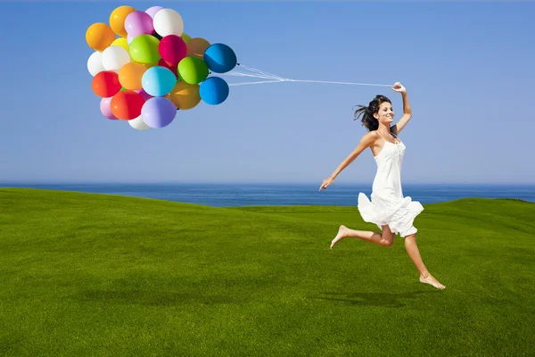 Saltando com um balões coloridos — Fotografia de Stock