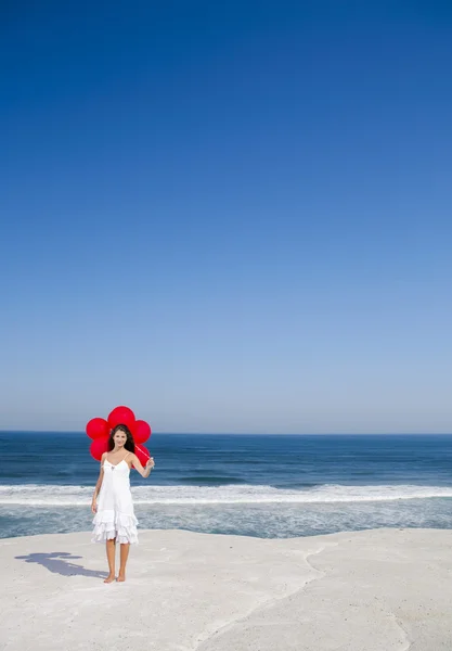 Beautiful girl holding red ballons — Stock Photo, Image