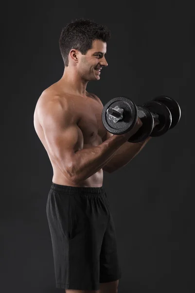 Homem muscular levantando pesos — Fotografia de Stock