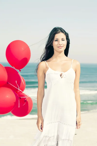 Beautiful girl holding red ballons — Zdjęcie stockowe