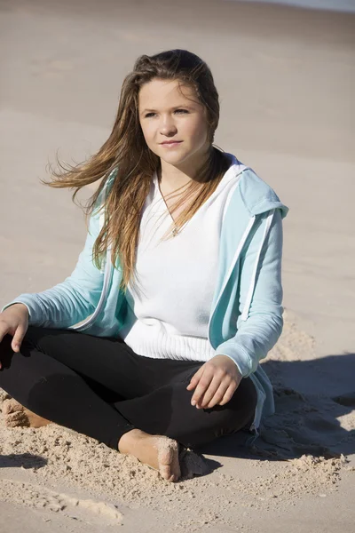 Meisje zit in het strand — Stockfoto