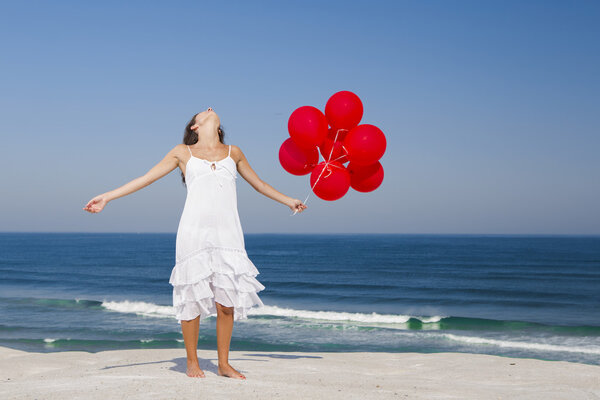 Beautiful girl holding red ballons