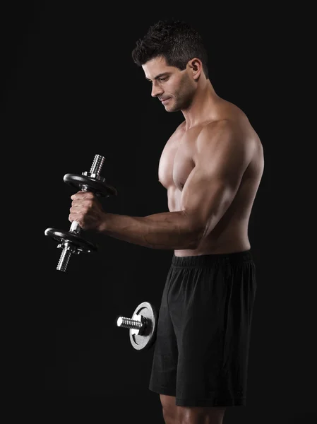 Muscular man lifting weights — Stock Photo, Image