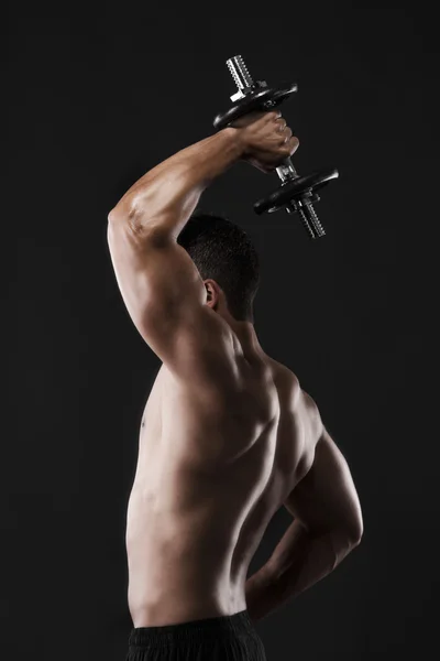 Muscular man lifting weights — Stock Photo, Image