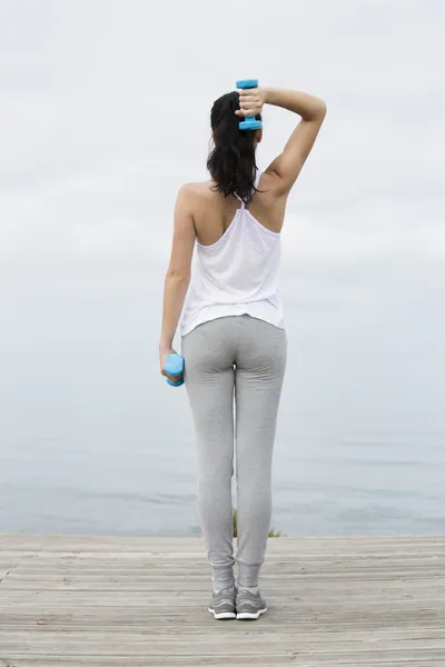 Женщина делает упражнения с гирями — стоковое фото