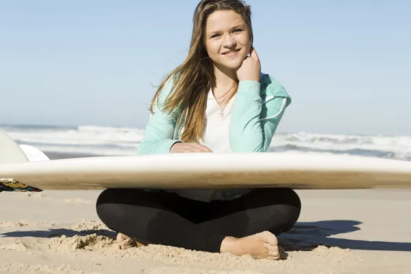 Девушка на пляже с доской для серфинга — стоковое фото