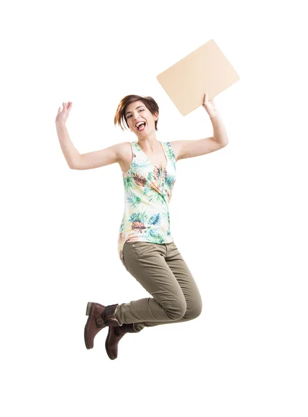 Mulher bonita pulando e segurando um papelão — Fotografia de Stock