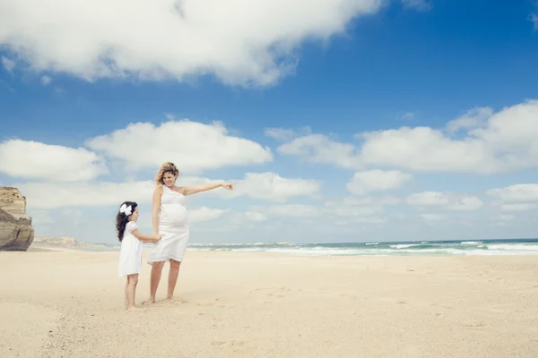 Schwangere Frau und ihre Tochter am Strand — Stockfoto