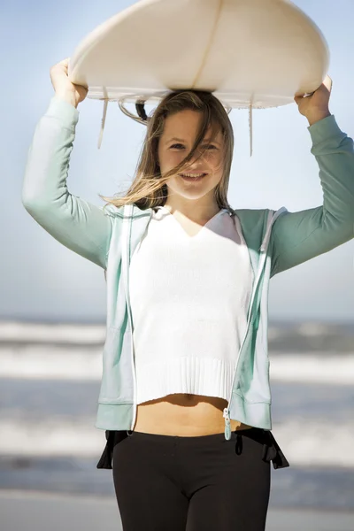 Girl in the  holding a surfboard over her head — Stock Photo, Image