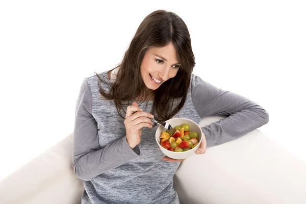 Mulher relaxante e comer salada de frutas — Fotografia de Stock