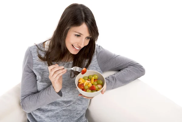 Mulher relaxante e comer salada de frutas — Fotografia de Stock