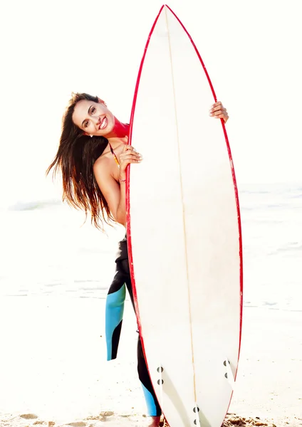 サーファーの女の子彼女のサーフボードを抱えて — ストック写真