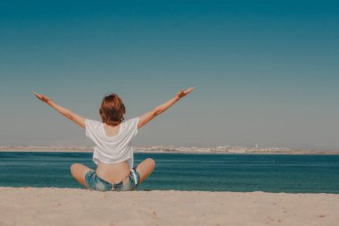 Güzel bir kadın sahilde eğleniyor.