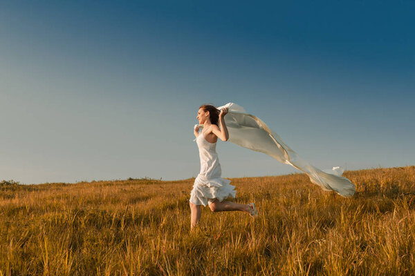 Young beautiful woman running while holding a white tissue