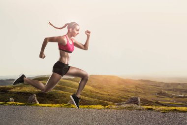 Shot of a sporty young woman runing and jumping  clipart