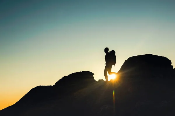 Aufnahme Eines Mannes Der Bei Sonnenuntergang Über Die Berge Geht — Stockfoto