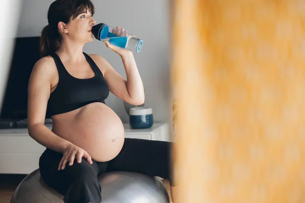 Hamile Bir Kadın Evde Antrenman Yaptıktan Sonra Içiyor Bebeği Beklerken — Stok fotoğraf