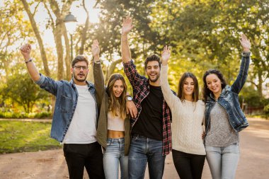 Dostlar kucaklaşır, kollar havada.