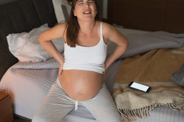 Mujer Joven Embarazada Dolorosa Casa Llamando Asistencia Médica Por Teléfono —  Fotos de Stock