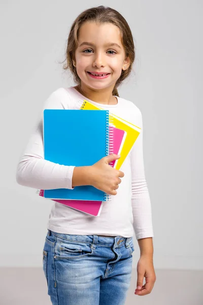 微笑学生小姑娘抱着笔记本 — 图库照片
