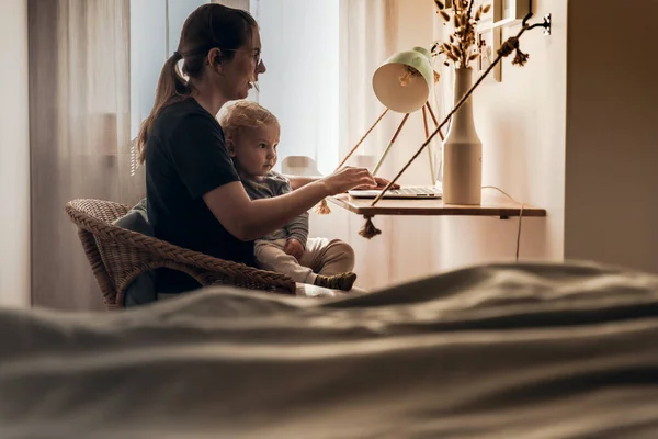 忙しい女性仕事で家で赤ちゃんと一緒に — ストック写真