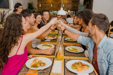 Bir grup arkadaş restoranda kadeh kaldırıyor ve eğleniyorlar.