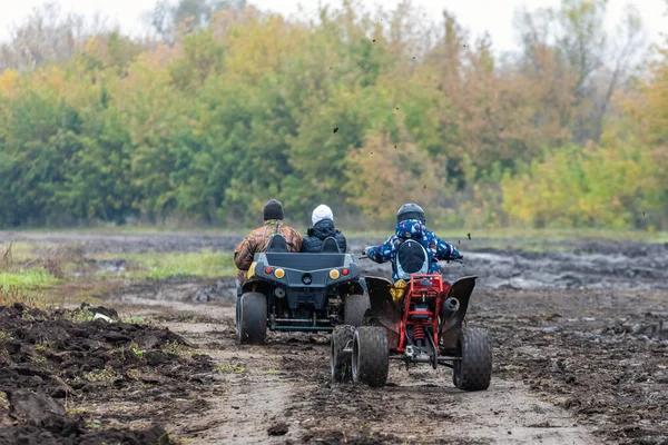 Orosz kaukázusi család nyaralás lovaglás quadricycle a felhős hideg őszi napon — Stock Fotó