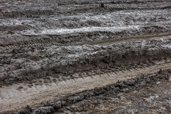 Våt grusväg efter regn. Lera, smuts och jord i grumligt dagsljus under höstsäsongen. — Stockfoto