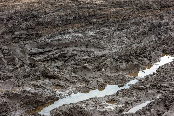雨后乡间小路破烂不堪.雨后在土路上打滚.粘土、泥土和水坑在雨后的阴天光照下，秋天. — 图库照片