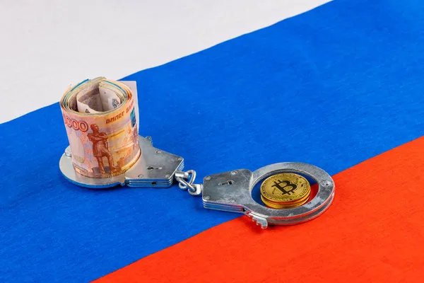 ロシア語の紙のロールは、ロシアの国旗の背景に手錠で鎖通貨とビットコインの輝きをルーブル — ストック写真
