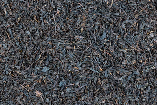 Zökkenőmentes textúra és teljes keret háttér lapos halom száraz hosszú távú fekete tea — Stock Fotó