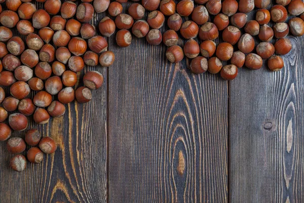 Noisettes avec coquilles posées sur la surface de la table en bois brun — Photo