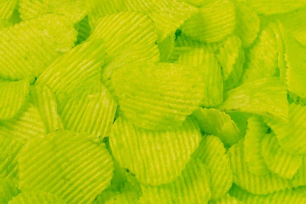 Yakın plan yeşil dalgalı patates cipsi yığını arka plan — Stok fotoğraf