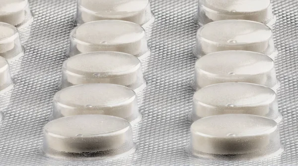 Generic white medical tablets in silver foil blister — Stock Photo, Image