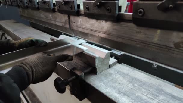 Doblando una gruesa lámina de metal en una máquina dobladora, de cerca. operador de la máquina dobla una hoja de metal. — Vídeo de stock